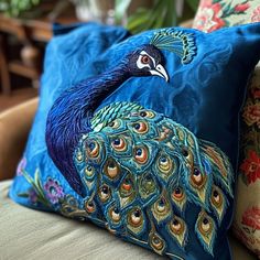 a peacock pillow sitting on top of a couch