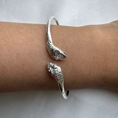 Crafted from solid .925 sterling silver, this Snake Bangle embodies transformation and eternal elegance— honored symbols. A perfect symbol of rebirth and divine authority, it offers a meaningful gift or a special touch to your collection. Ideal for the modern woman who carries the essence of strength and renewal. Material & Features: • Solid .925 Sterling Silver Bangle Bracelets• Bangle thickness: approximately 2.5 mm• Standard size: 8", weight approximately 15 grams for the piece• Available siz Flexible Sterling Silver Bracelets For Formal Occasions, Elegant Adjustable Bangle With Sterling Silver Clasp, Adjustable White Gold Bangle With Sterling Silver Clasp, Sterling Silver Jubilee Cuff Bracelet, Sterling Silver Jewelry With Polished Snake Chain, Sterling Silver Snake Chain Jewelry With Polished Finish, Sterling Silver Clasp Bangle For Gift, Adjustable Bracelet With Sterling Silver Clasp And Snake Chain, Adjustable Silver Sterling Silver Bangle