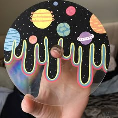 a person holding up a sticker with planets on it