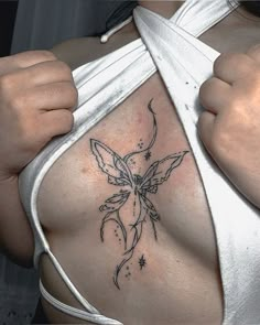 a close up of a person with a tattoo on their chest and shoulder, holding onto the side of her body