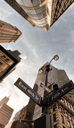 looking up at street signs and skyscrapers in new york city, ny on east 10th st