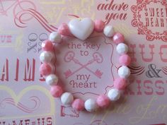 This is a Valentine Heart Beaded Bracelet. It has a white pearl heart pony bead in the middle. It has white and pink solid 8mm faceted beads. It was made with .8mm sturdy stretch string. I tie it several times to prevent breakage. It fits girls ages 5-10. It stretches to fit on the wrist. It would make a cute gift for a little girl for Valentine's Day. It would make a cute gift for a little girl's Birthday. All items are ready to be shipped I do combined shipping. Items ship in 2-5 business days Sweet White Jewelry For Valentine's Day, Cute Heart Beaded Bracelets For Valentine's Day, Cute Heart Beads Beaded Bracelets For Valentine's Day, Sweet White Jewelry With Heart Beads, Cute Heart-shaped Beaded Bracelets For Valentine's Day, Cute Heart Beads Friendship Bracelets For Valentine's Day, Cute Valentine's Day Friendship Bracelets With Heart Beads, Cute Beaded Friendship Bracelets For Valentine's Day, Birthday Stretch Bracelet With Heart Beads