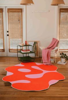 an orange and pink rug in the middle of a room with two lamps on either side