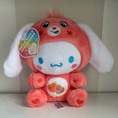 a pink stuffed animal with white ears and blue eyes