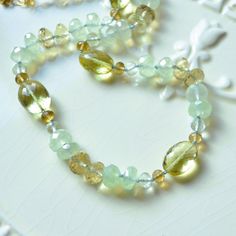 "This luxe gemstone necklace is a stunning piece of jewellery that you will treasure forever. Over four dozen sparkly beads are strung onto light blue silk cord, creating a stunning necklace of subtle colours. A tiny knot separates each stone, which results in a beautiful drape. The stones are about 4mm - 12mm in size, and contain lemon quartz in two shades of yellow, pale green amethyst, rich beer quartz, and mystic green chalcedony. This colour combination is unexpected and so pretty. A small Luxury Adjustable Hand Knotted Necklaces, Elegant Adjustable Emerald Necklace With Natural Stones, Elegant Amber Beaded Necklaces For Healing, Amber Gemstone Necklace For Anniversary, Elegant Amethyst Necklace For Healing, Luxury Faceted Necklaces For Jewelry Making, Luxury Faceted Beaded Necklace For Gift, Elegant Rondelle Emerald Necklace With Natural Stones, Adjustable Necklace With Gemstone Accents