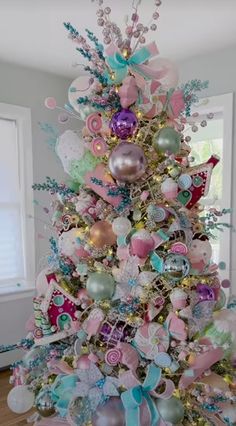 a pink and blue christmas tree with lots of ornaments