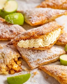 several pastries on a white plate with limes and other food items around them