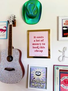 there is a guitar on the wall next to pictures and magnets that say it cost a lot of money to look this cheap