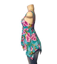 Take this top on vacation with you this year! It is a very cute baby doll blue top, material is soft to the touch and has a floral print to it in blue, purple, and yellow times. is true to size.Has lots of stretch! Would make a good pregnancy top. Material is 65% spandex and 35% polyester Fitted Tropical Floral Print Top, Light Blue Tops For Vacation, Blue Summer Tank Top For Vacation, Fitted Floral Print Tank Top For Beach Season, Fitted Floral Print Tank Top For Vacation, Blue Beachwear Tank Top For Summer, Blue Beachwear Tank Top For The Beach, Stretch Printed Tops For Beach Season, Blue Stretch Tank Top For Beachwear