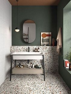 a bathroom with green walls and flooring has a sink, mirror, and shelf