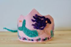 Pink Birthday Crown with Mermaid | Waldorf Inspired |Felted Birthday Hat | Girl Birthday Every birthday is a milestone in your child's life. Add some magic in the celebration and create memories that will last forever with this dreamy pink mermaid  birthday crown ! Inspired by the Waldorf pedagogy, this crown is completely handmade with lots of love and care for your beloved one! Let the mermaids take you under the sea and discover the treasures of the ocean... | DIMENSIONS | Crown Length: 29cm / 11 inches Crown Height: 13 cm / 5 inches at the highest point Ribbon: About 25 cm /9,5  inches on each side Fits all head sizes as is tied with a braided ribbon. | MATERIALS | The base and design are made of 100% sheep wool, but since wool felt is a bit itchy, the backing is made of synthetic felt Mermaid Birthday Crown, Whimsical Adjustable Pink Crown, Adjustable Pink Crown With Round Shape, Whimsical Pink Crown For Birthday, Waldorf Birthday Crown, Sea Crown, Dreamy Birthday, Braided Ribbon, Birthday Crowns