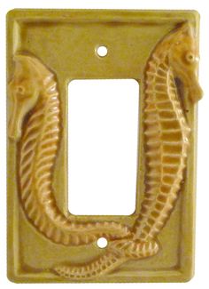 a light switch cover with a seahorse on it