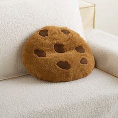 a cookie shaped pillow sitting on top of a white couch