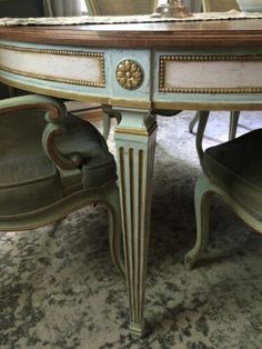 an antique dining table with chairs around it