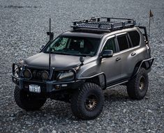 a silver four - door suv parked on gravel