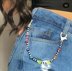 a close up of a woman's stomach wearing a jean skirt with an animal beaded necklace on it