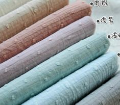 four rolls of fabric with water droplets on them in different colors and sizes, sitting next to each other