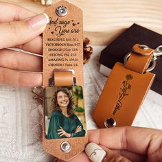 a person holding a keychain with a picture on it next to other items