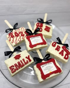 four decorated cookies on a glass plate with black ribbon and bow around the edges that read, happy 3rd grade