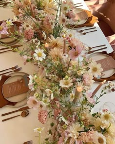 an arrangement of flowers on a long table