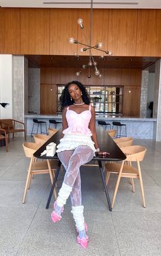 a woman sitting on top of a wooden table