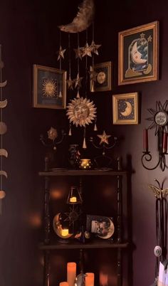 a shelf with candles and pictures on it in a room that is dark purple colored