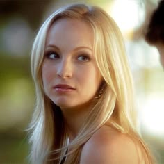 a beautiful blond woman standing next to a man