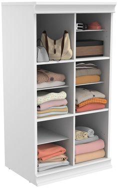 a white closet filled with lots of folded clothes and bags on top of it's shelves