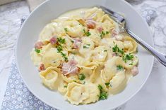 a white bowl filled with pasta and ham