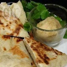 two quesadillas cut in half on a plate next to a small bowl of dipping sauce