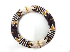 Beautiful beaded authentic bold thick bangle handmade by Zulu women in South Africa. Bangle is handmade using glass beads, yarn and cotton. We directly work with Zulu women to produce and market high-end beaded jewelry based on traditional beading techniques infused with modern aesthetics. Our bangles are created entirely by hand and variations in design may occur. Each piece tells a story. Beaded jewelry is part of the Zulu identity and through our collection, we tell their stories and preserve Traditional Handmade Brown Stretch Bracelet, White Handwoven Bracelets, White Handwoven Bracelets With Round Beads, Traditional Handmade Brown Bangle, Festive Handmade Beaded Bracelets, White Beaded Bangle Bracelets For Festive Occasions, Handwoven Beaded Bracelets With Round Beads, Traditional White Handwoven Bracelet, Traditional White Handwoven Bracelets