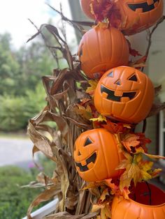 three pumpkins that are sitting on top of a planter in front of a house