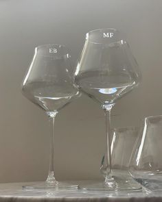 three wine glasses sitting on top of a table