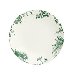 a white plate with green flowers and leaves on the rim, against a white background