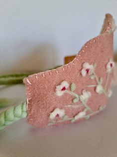 a close up of a piece of fabric with flowers on it and a green cord