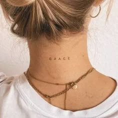 a woman's neck with the word grace tattooed on her left side ribcage