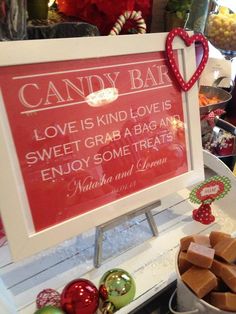 a candy bar sign is on display in front of other candies and sweets for sale