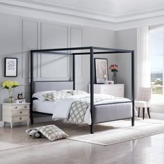 a bedroom with a four poster bed and white walls