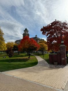 a brick walkway in front of a large building with a clock tower on the top