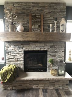 a living room with a stone fireplace and wooden floors