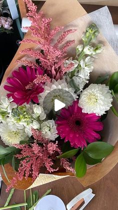 a bouquet of flowers sitting on top of a table next to a knife and fork