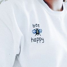 a close up of a person wearing a bee happy shirt