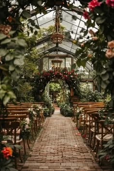 the inside of a greenhouse filled with lots of flowers and greenery on both sides of the walkway