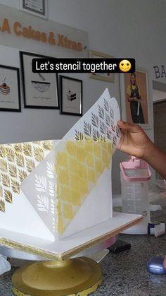 someone is decorating a cake with yellow and white icing on the top layer