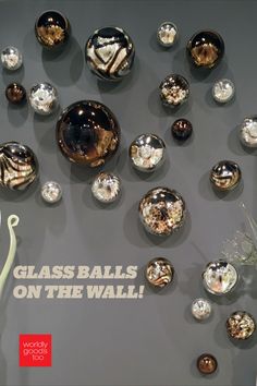 there are many glass balls on the wall in this display case and it says, glass balls on the wall