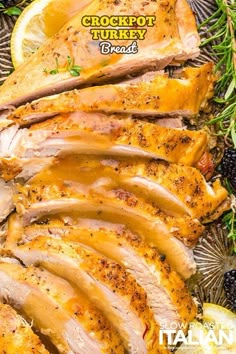 sliced turkey on a platter with lemons and herbs