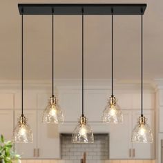 an image of a kitchen light fixture with five lights hanging from it's ceiling