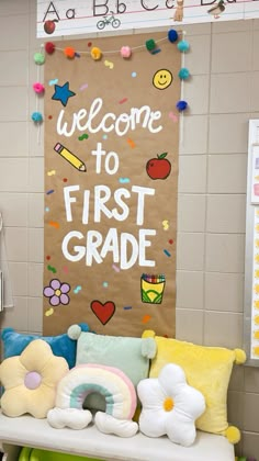 a welcome to first grade sign in front of a bulletin board with flowers and balloons