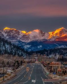 the mountains are covered in snow at sunset