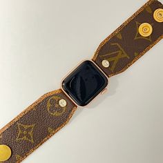 Introducing "Samantha Anne" - a custom-made apple watch band that exudes sophistication and style! Hand-crafted with precision and care, this designer watchband features soft variegated tan/coffee leather, complemented by the classic brown and gold LV monogram material sourced from authentic bags. The band is meticulously secured with gold fitting connectors, ensuring a snug fit for your apple watch. Designed for both adjustability and comfort, two gold high-quality snaps have been incorporated Modern Brown Leather Apple Watch Band, Classic Brown Apple Watch Band For Everyday Use, Modern Brown Apple Watch Band For Everyday Use, Brown Leather Strap Apple Watch Band, Luxury Leather Strap Bracelets For Everyday Use, Modern Brown Watch Accessories For Everyday, Trendy Brown Bracelet Strap Watch Band, Trendy Brown Watch Band With Bracelet Strap, Classic Brown Rectangular Apple Watch Band